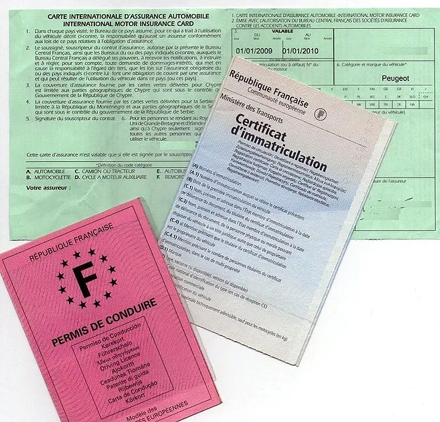 Certificat d'immatriculation français (carte grise) posé avec une carte verte d'assurance et un permis de conduire