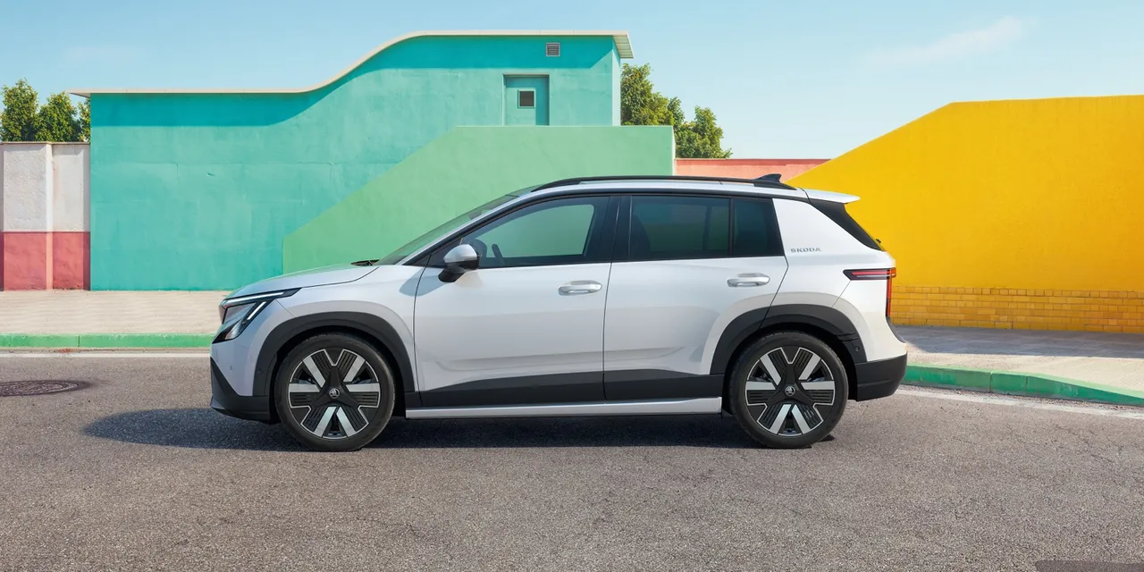 Le Skoda Epiq 2026, petit SUV électrique, de profil devant des façades colorées