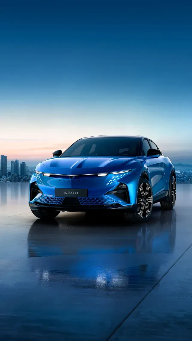 Alpine A390 électrique bleue de trois quarts avant devant une skyline au crépuscule