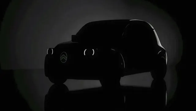 Teaser officiel de la future Citroën 2CV électrique, silhouette sombre avec le logo Citroën éclairé