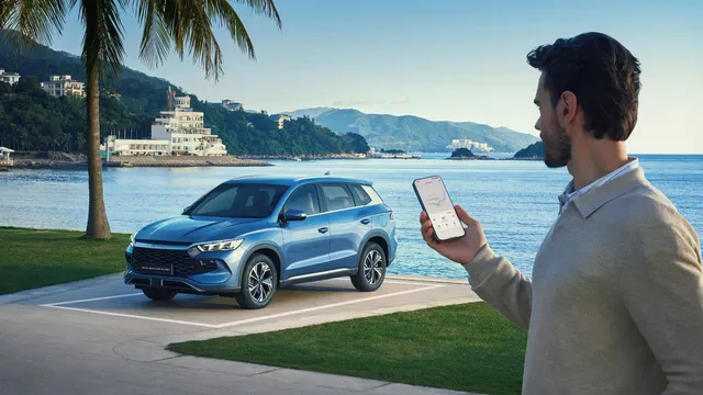 SUV BYD Sealion 5 DM-i bleu stationne au bord de l'eau, hybride rechargeable familial