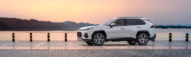 Suzuki Across 2026, SUV hybride rechargeable blanc de profil au bord de l'eau