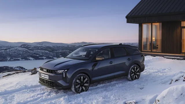 La Dacia Striker 2026, break crossover bleu foncé, de profil dans un décor de montagne enneigée
