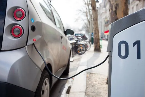 Voiture électrique branchée à une borne de recharge dans une rue, illustration du bonus écologique 2026