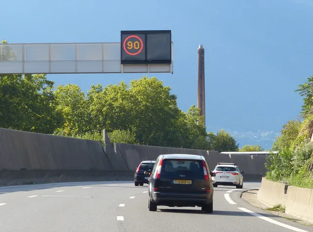 Panneau lumineux affichant 90 km/h au-dessus d'une route française avec plusieurs voitures