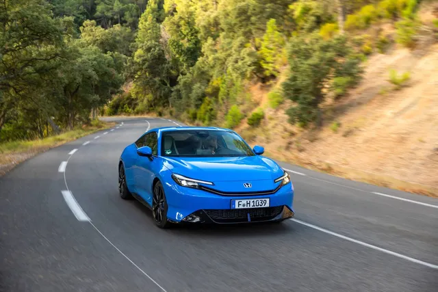 Honda Prelude 2026 bleue, coupé hybride, vue avant trois quarts sur route