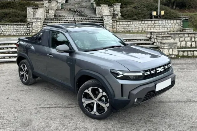 Dacia Duster pick-up gris simple cabine, vue trois-quarts avant, avec benne à l'arrière