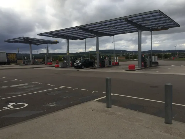 Station-service sur une aire d'autoroute en France avec ses pompes à carburant sous auvent