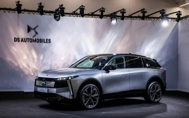 DS N°7, grand SUV premium français, présenté sous les projecteurs devant le logo DS Automobiles