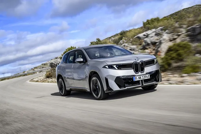 BMW iX3 Neue Klasse 2026 grise de trois quarts avant sur une route de montagne