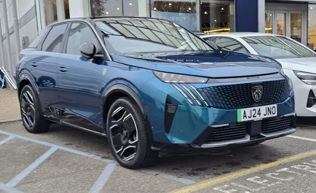 Peugeot 3008 de troisième génération vue de trois quarts avant, garée devant une concession